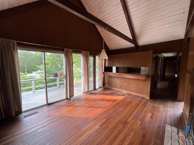 unfurnished living room featuring high vaulted ceiling, beam ceiling, dark wood-type flooring, and wooden ceiling