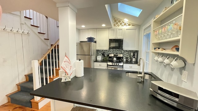 40 Brant Rock Rd, Mashpee, MA 02649 - kitchen with appliances with stainless steel finishes, dark countertops, backsplash, white cabinets, and vaulted ceiling