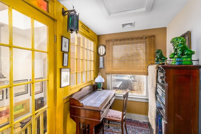 office space with baseboards, visible vents, and a raised ceiling