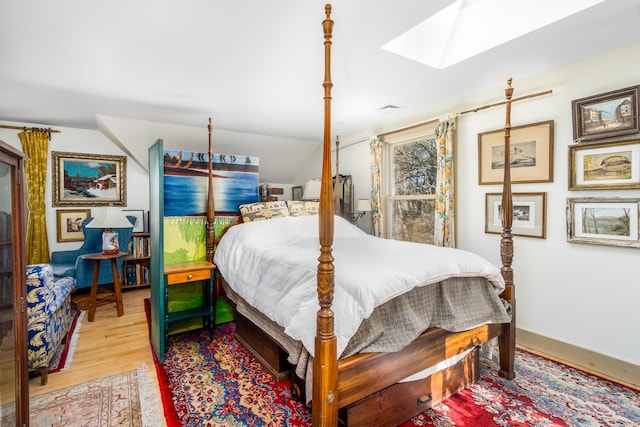 bedroom featuring a skylight, visible vents, and wood finished floors