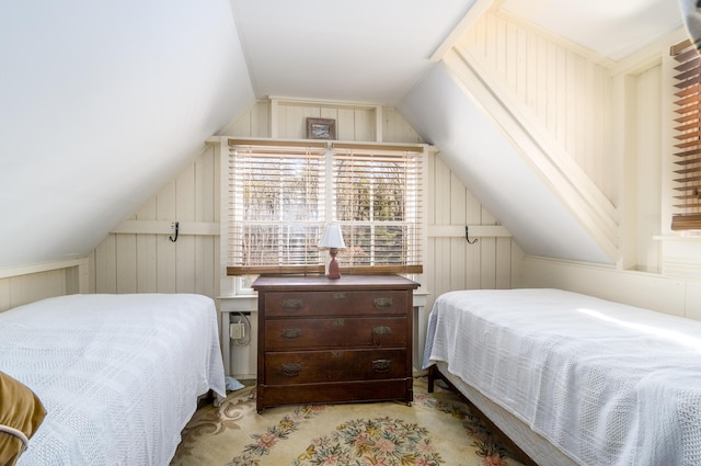 bedroom featuring vaulted ceiling and wood walls