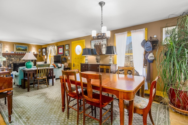 dining space with a fireplace and a notable chandelier