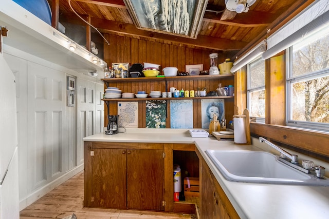 kitchen with a sink, wood ceiling, open shelves, and light countertops