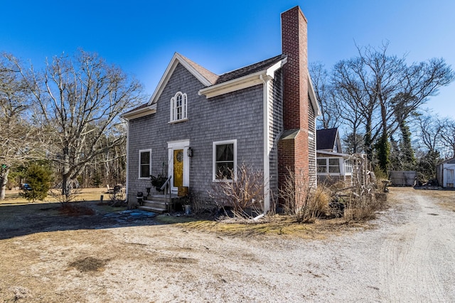 view of front of home featuring a shingled roof and a chimney