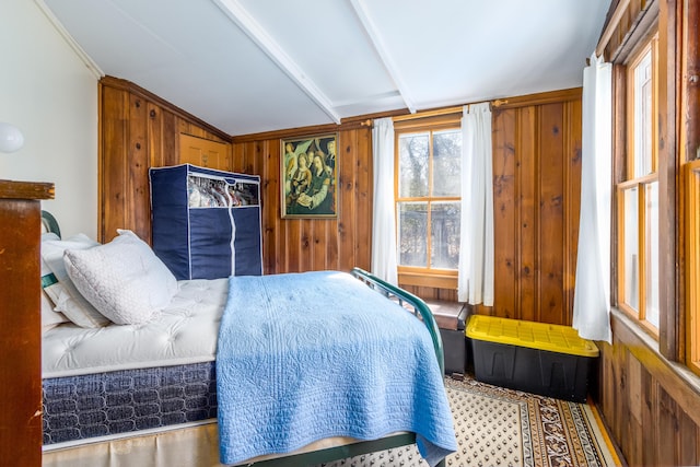 bedroom featuring wood walls and vaulted ceiling