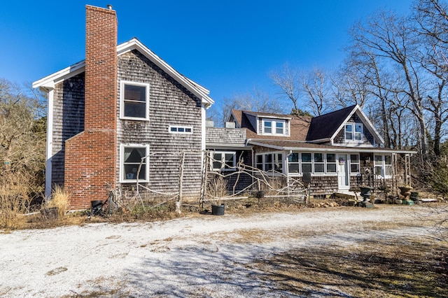 back of property featuring a sunroom and a chimney