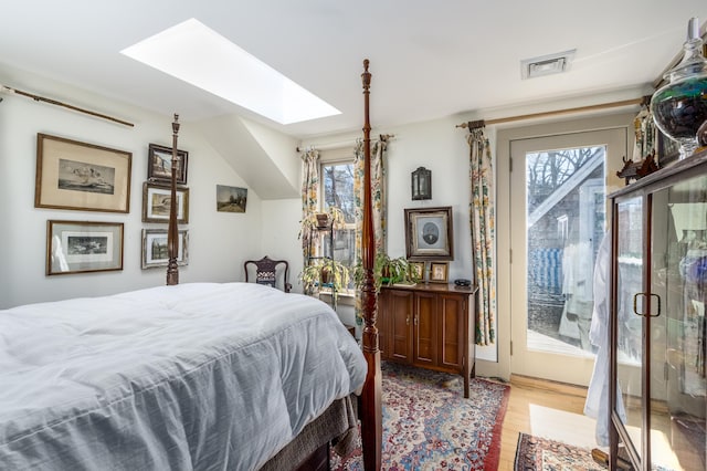 bedroom featuring a skylight, wood finished floors, visible vents, and multiple windows