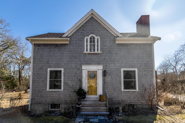 view of front of property featuring entry steps and a chimney