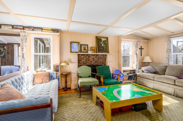 playroom featuring lofted ceiling with beams and a brick fireplace