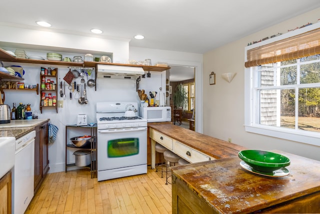 kitchen with open shelves, recessed lighting, light wood-style floors, white appliances, and under cabinet range hood