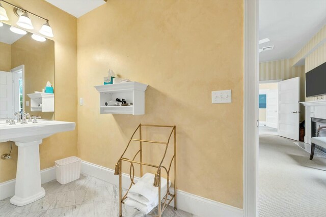 143 Main St, Sandwich, MA 02563 - bathroom featuring a glass covered fireplace, visible vents, marble finish floor, and baseboards