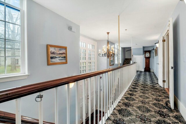 143 Main St, Sandwich, MA 02563 - corridor featuring dark colored carpet, a healthy amount of sunlight, and an inviting chandelier