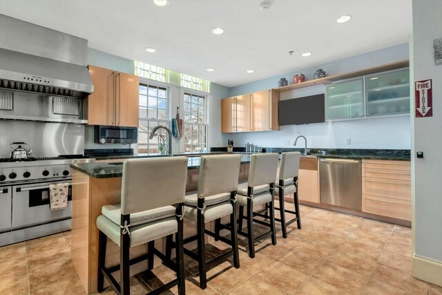 143 Main St, Sandwich, MA 02563 - kitchen with a kitchen bar, wall chimney exhaust hood, stainless steel appliances, and a center island with sink