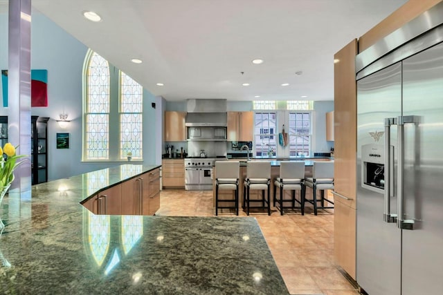 143 Main St, Sandwich, MA 02563 - kitchen featuring dark stone counters, a sink, premium appliances, and recessed lighting