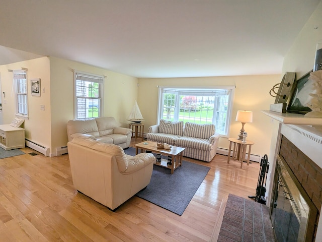 32 Apple Ln, Dennis, MA 02638 - living area with light wood-type flooring, a fireplace with flush hearth, and a baseboard radiator