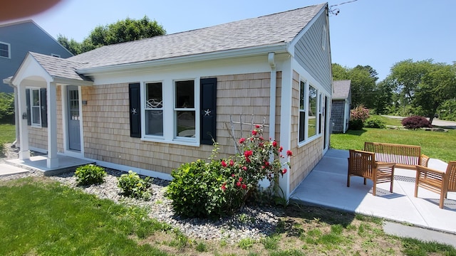 2-A Bodfish Ave, Sandwich, MA 02563 - view of side of home featuring a shingled roof, a patio, and a lawn