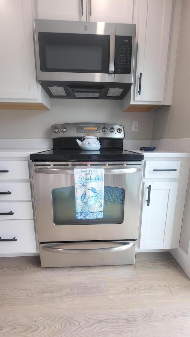 2-A Bodfish Ave, Sandwich, MA 02563 - kitchen with stainless steel appliances, white cabinetry, light wood-style floors, and light countertops