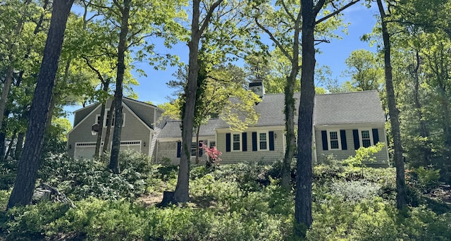 91 Hitching Post Ln, Centerville, MA 02632 - view of front facade featuring an attached garage, a chimney, and roof with shingles