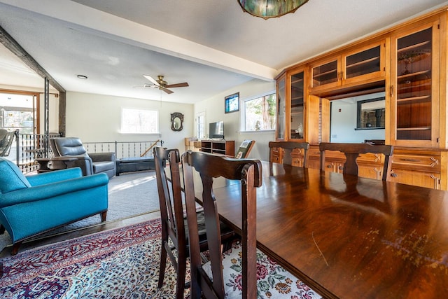 dining space with ceiling fan and beamed ceiling