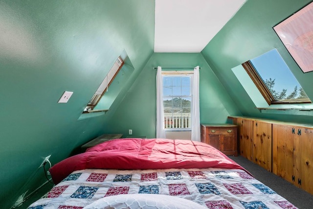 carpeted bedroom featuring vaulted ceiling with skylight