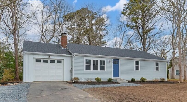 ranch-style house with board and batten siding, a chimney, an attached garage, and aphalt driveway