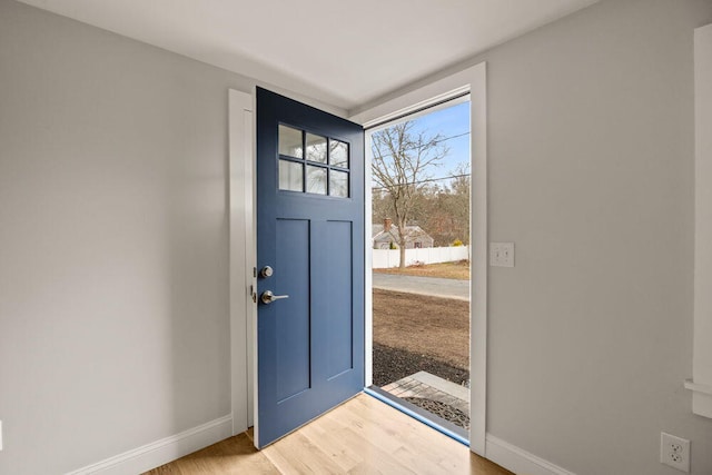 foyer with baseboards and light wood-style flooring