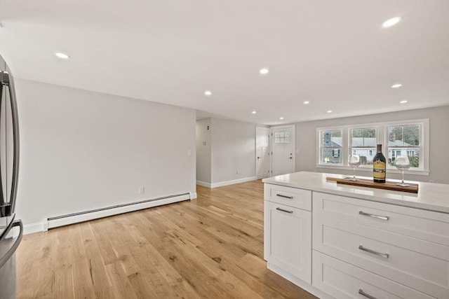 kitchen featuring white cabinets, recessed lighting, a baseboard heating unit, and light wood-style flooring
