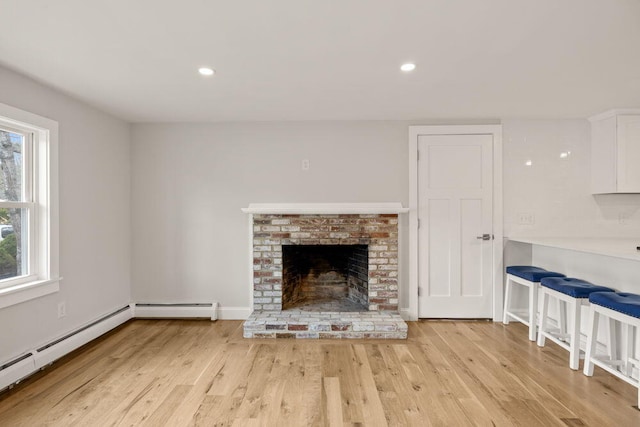 unfurnished living room featuring recessed lighting, light wood finished floors, a baseboard heating unit, and a fireplace