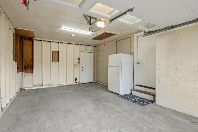garage featuring freestanding refrigerator and a garage door opener