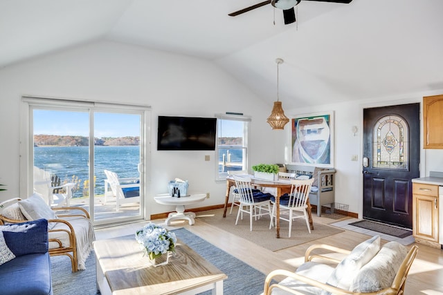 living area with lofted ceiling, baseboards, a ceiling fan, and a healthy amount of sunlight