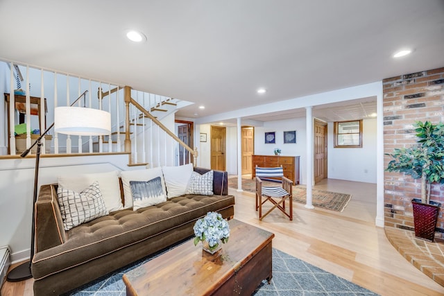 living room with a baseboard radiator, stairway, wood finished floors, and recessed lighting