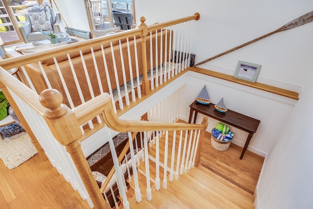 staircase with a wealth of natural light and wood finished floors