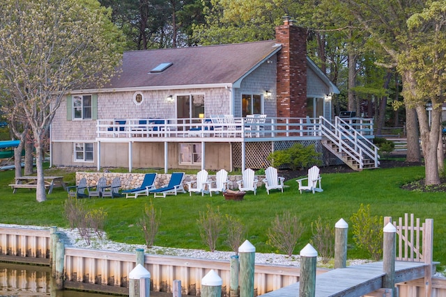 30 Overland Rd, Mashpee, MA 02649 - rear view of house featuring a wooden deck, a lawn, a chimney, and a shingled roof