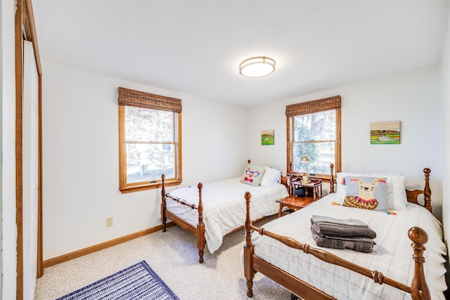 bedroom with light carpet and baseboards