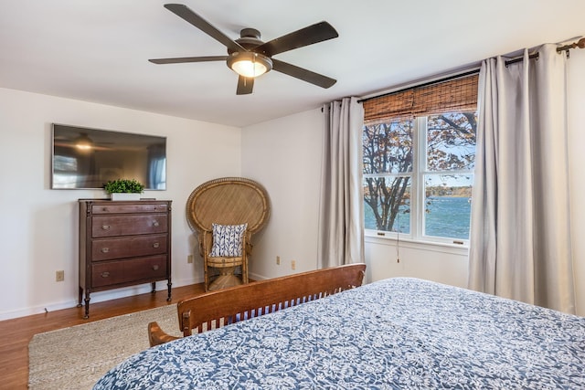 bedroom featuring a ceiling fan, baseboards, and wood finished floors