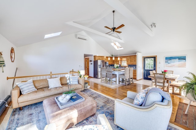 living area featuring a skylight, light wood-style flooring, a wall mounted AC, ceiling fan, and beamed ceiling