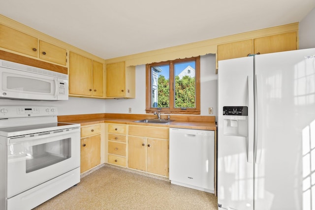 kitchen with white appliances, light brown cabinetry, light countertops, and a sink