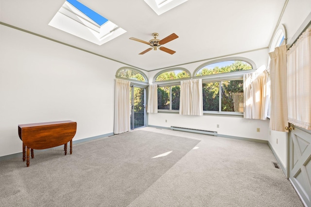 interior space with a skylight, plenty of natural light, carpet floors, and baseboard heating