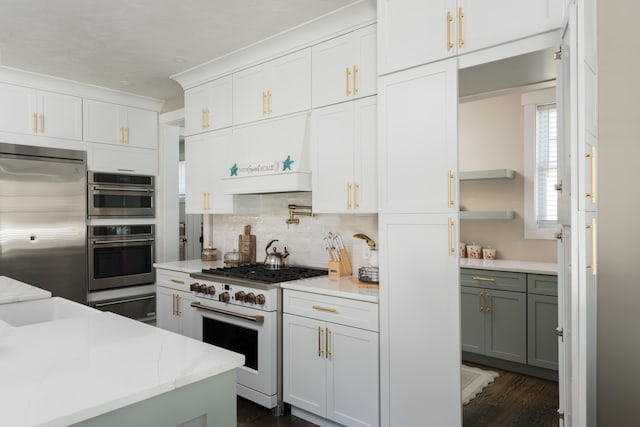79 Neshobe Rd, Mashpee, MA 02649 - kitchen with appliances with stainless steel finishes, a warming drawer, decorative backsplash, white cabinets, and dark wood-style flooring