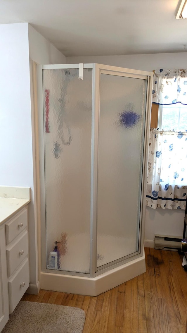 13 Pilgrim Ln, Eastham, MA 02642 - full bath with a stall shower, wood finished floors, vanity, and a baseboard heating unit
