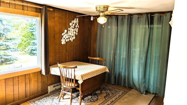 13 Pilgrim Ln, Eastham, MA 02642 - dining area featuring ceiling fan, wooden walls, healthy amount of natural light, wood finished floors, and a baseboard heating unit