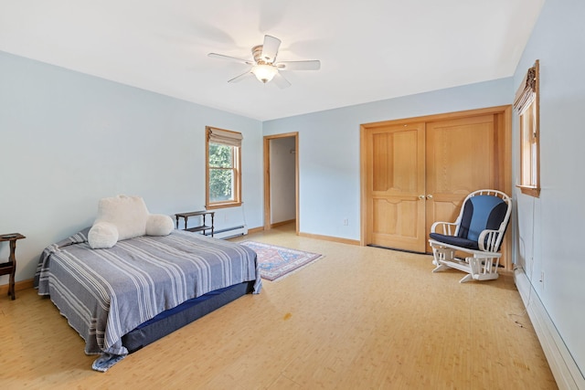 bedroom featuring baseboards, ceiling fan, light wood-type flooring, and baseboard heating
