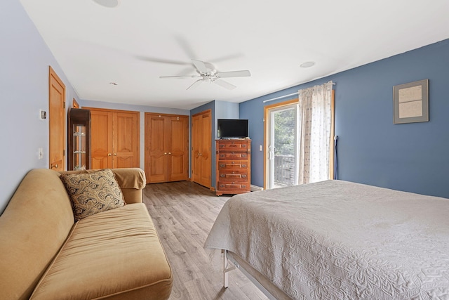 bedroom with access to exterior, ceiling fan, two closets, and light wood finished floors