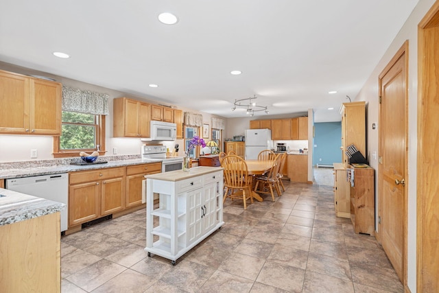 kitchen featuring a center island, white appliances, and recessed lighting