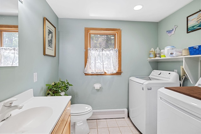 bathroom featuring a baseboard radiator, washing machine and clothes dryer, tile patterned flooring, and a wealth of natural light