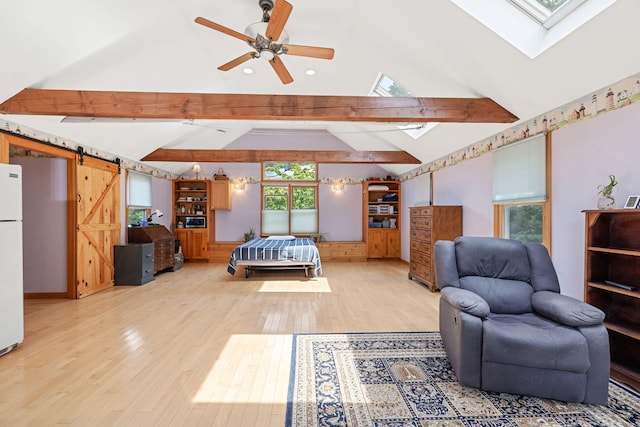 bedroom with light wood-type flooring, lofted ceiling with skylight, and freestanding refrigerator