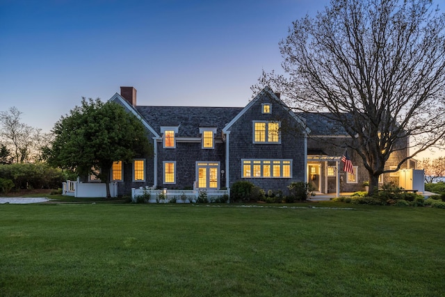 view of front of home featuring a lawn and a chimney