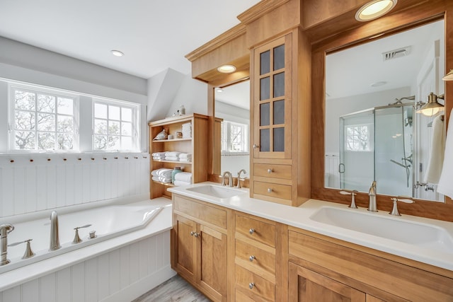 full bathroom featuring a stall shower, double vanity, a garden tub, and wood finished floors