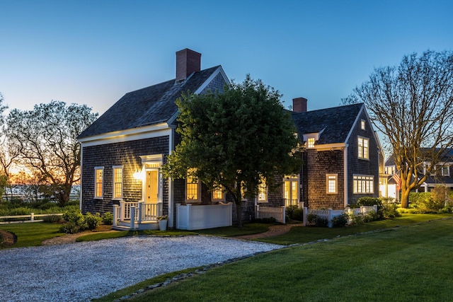 view of front facade with a front yard and a chimney