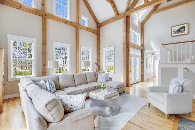 living room with high vaulted ceiling, wood finished floors, beamed ceiling, and baseboards